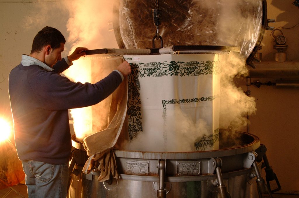 Artisan fixing the colour into the fabric through a steaming process