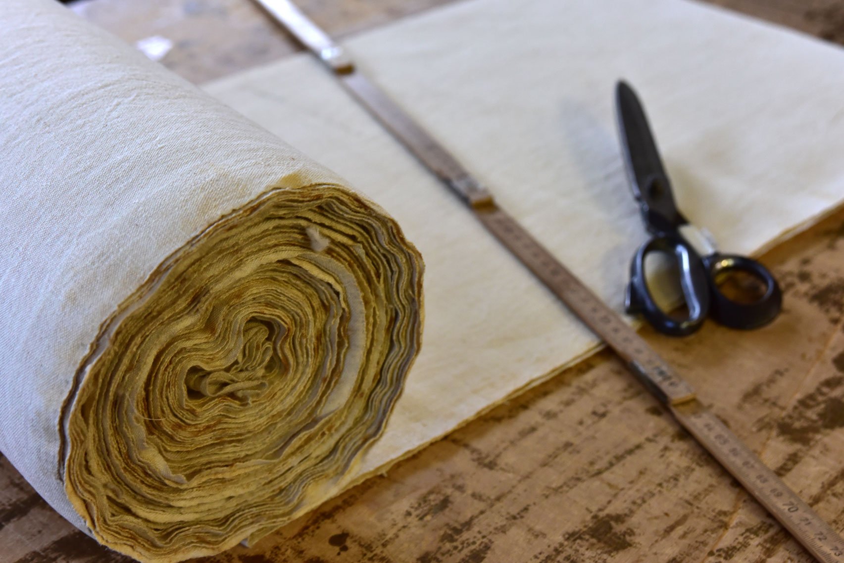 Bespoke Linen tablecloths - ruler and scissors sitting on top of a roll of fabric