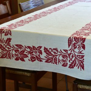 Farmhouse table runner with hand-printed pomegranate design laid on a wooden kitchen table