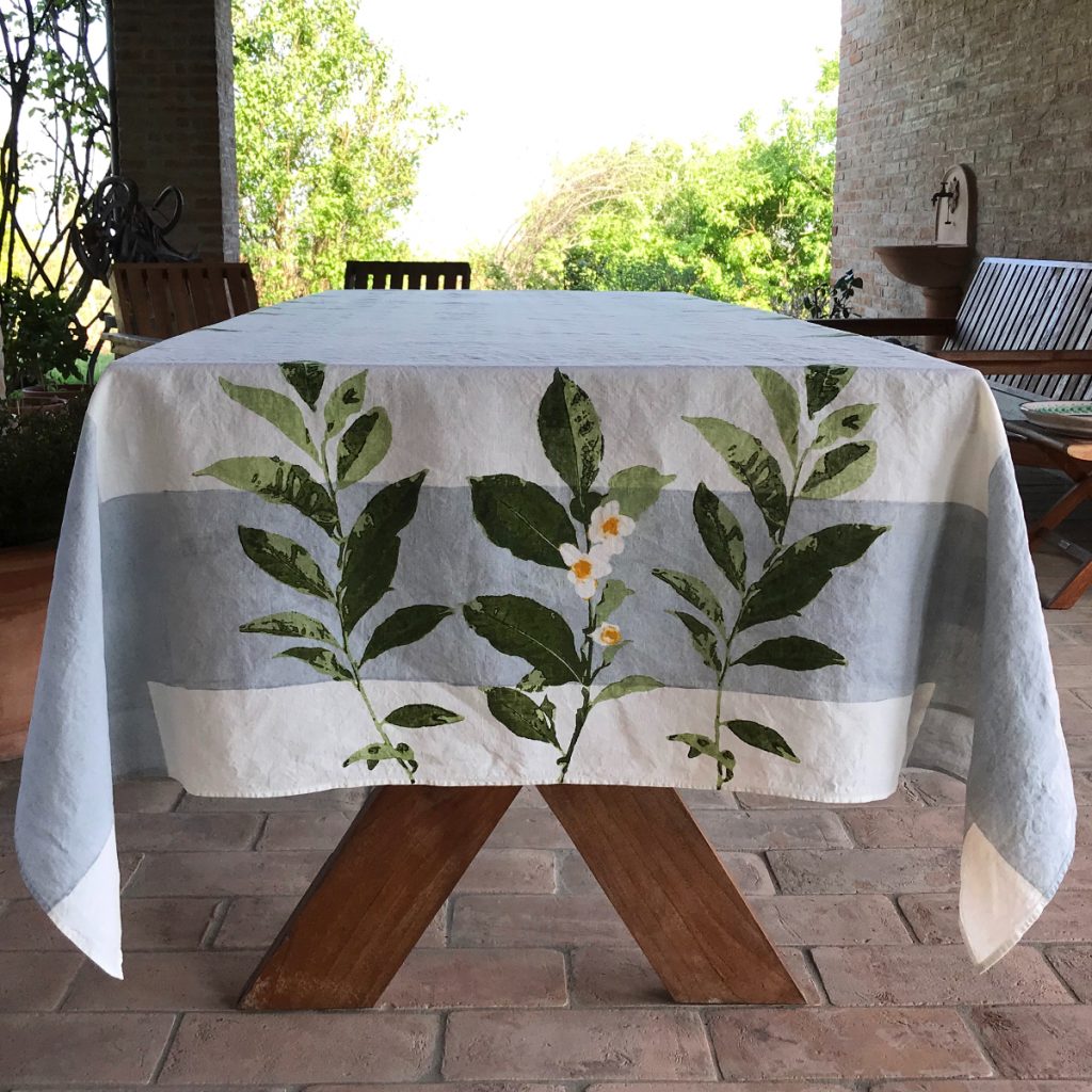 - Camellia linen tablecloth laid over a table outside on a patio. The table has not been laid.