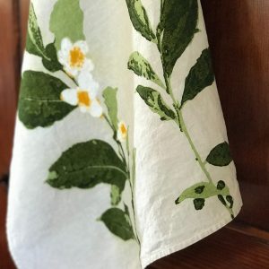 Close-up detailing of the motifs of the Camellia organic linen tea towel.