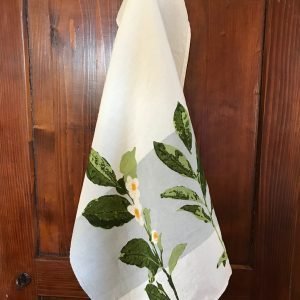 Camellia linen tea towel with band, hanging from a hook on a door.