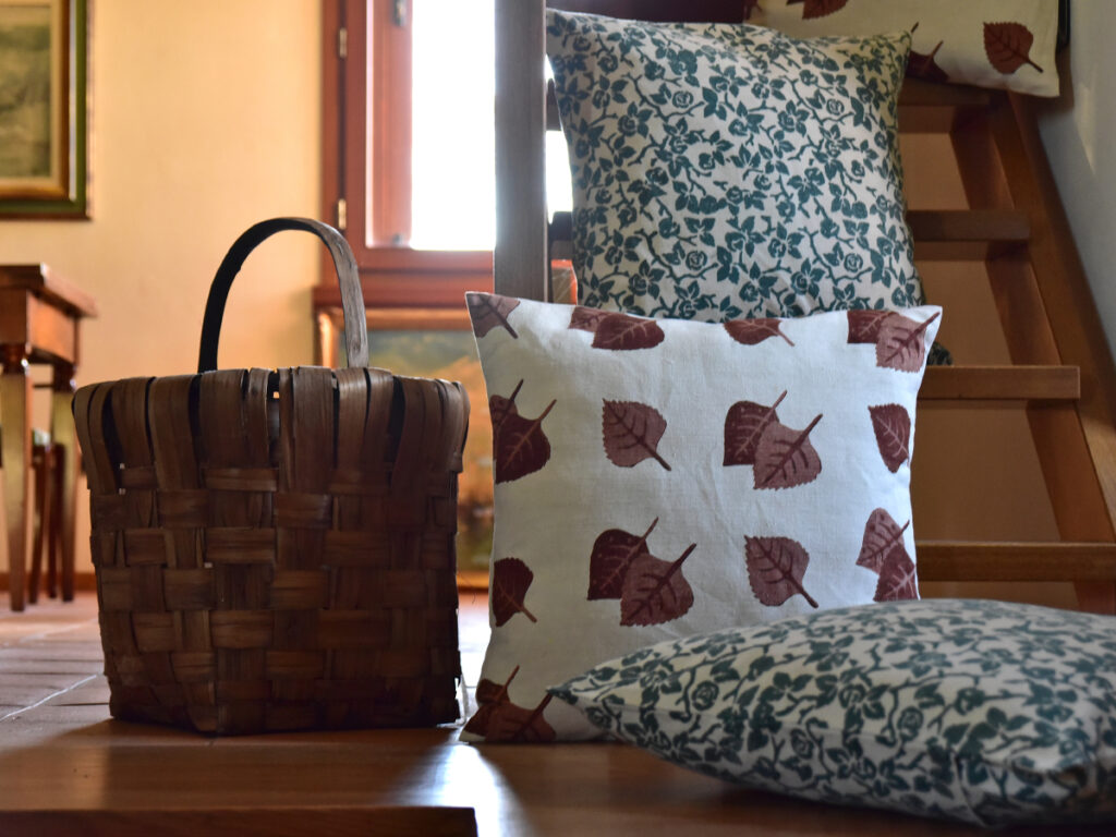 vintage cushion cover - vintage hemp linen - three cushions sitting on wooden floor beside wicker basket
