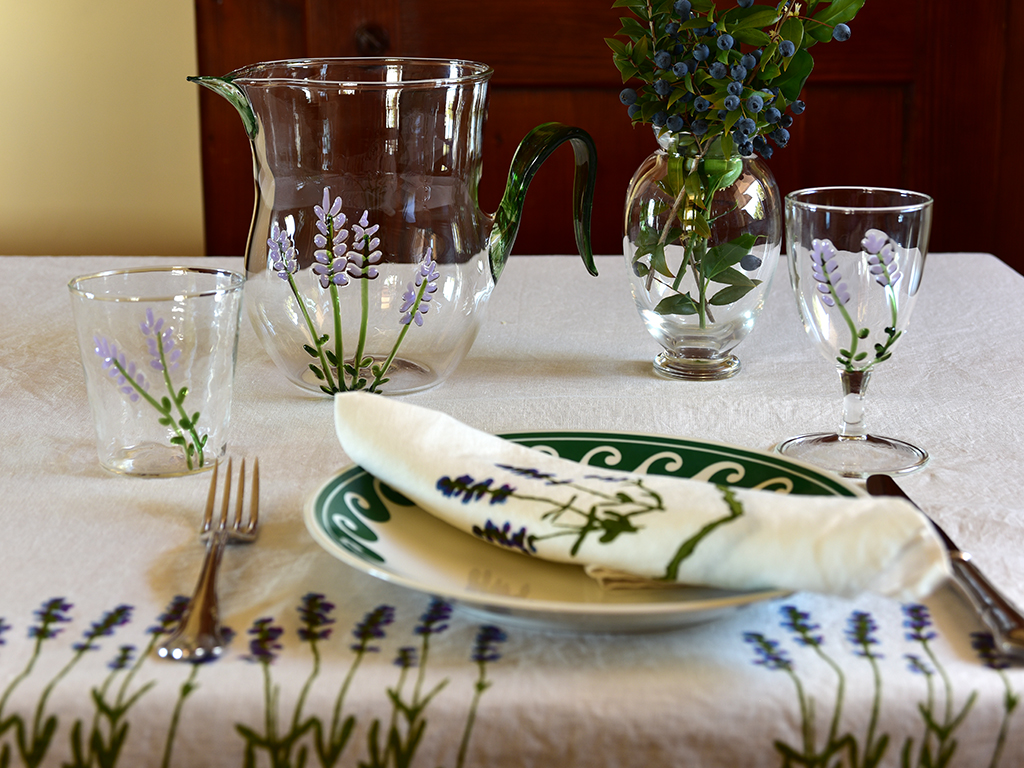 Murano glassware and jug placed beside ceramic plate, linen napkin and cutlery