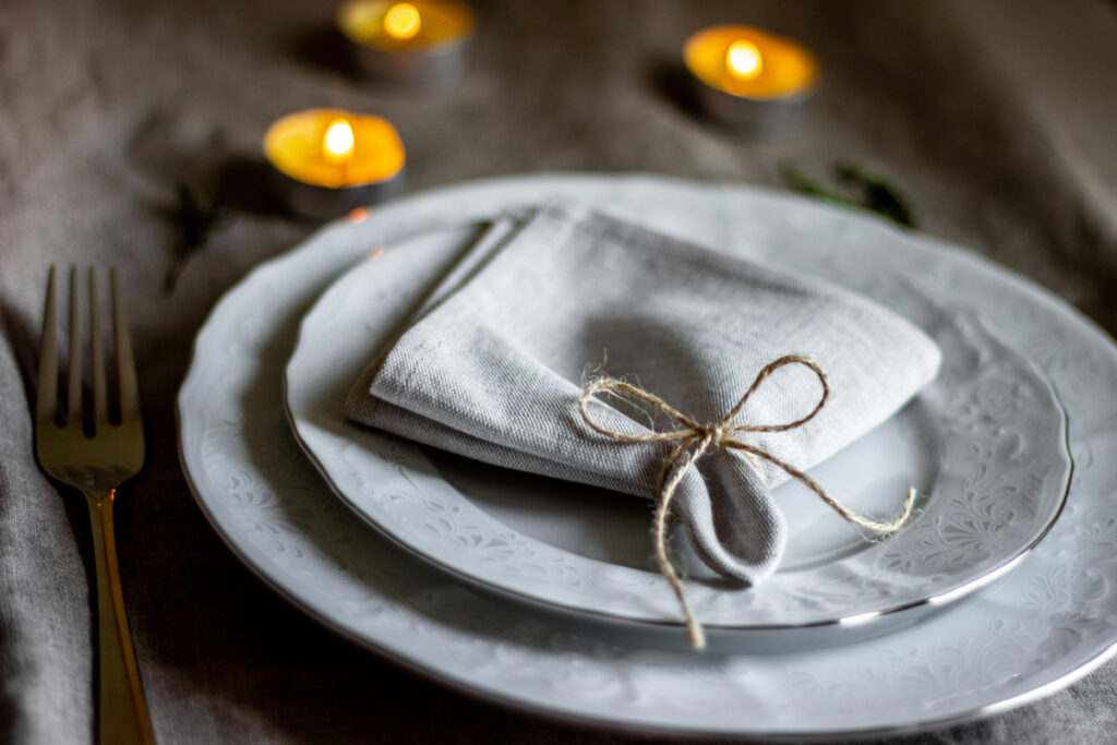 Dinner party setting - tied napkin placed atop ceramic plates