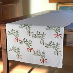 Fiocco table runner placed over table, decorative patterns are shown at runner's drop