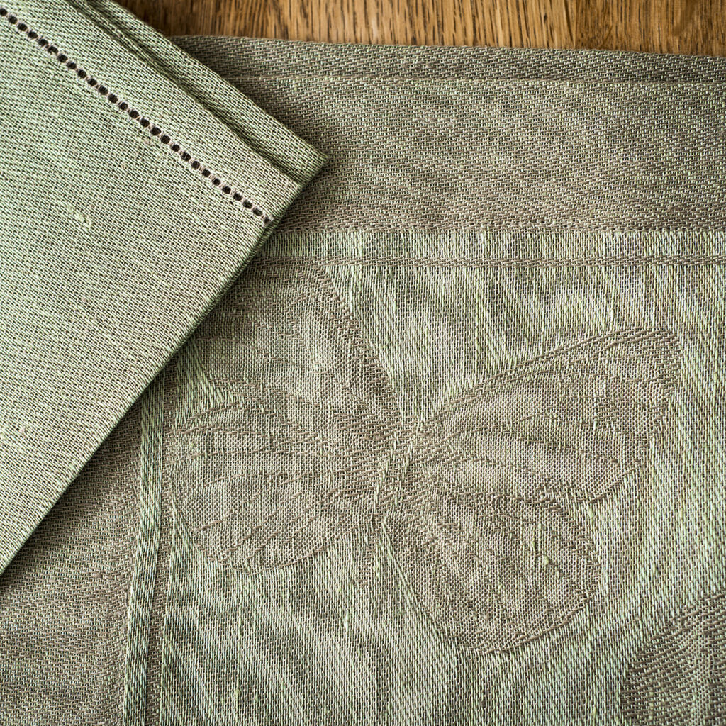 detail of a butterfly linen tablecloth in green colour