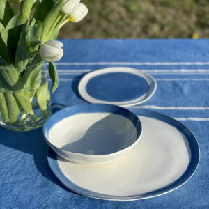 Easter table setting with an exclusive porcelain dinnerware set in blue and a vase of white tulip
