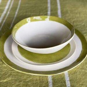 Porcelain dinnerware on a green linen tablecloth