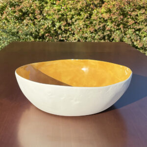 Mustard porcelain serving bowl on a wooden table