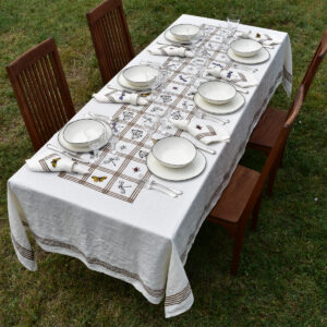 organic linen tablecloth laid on a table in the garden with porcelain dinnerware o top
