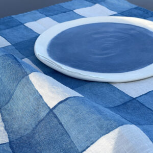 hand-crafted checked linen tea towel and handmade porcelain plate in blue colour