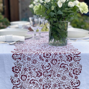 Floral linen tablecloth with a vase of white flowers on top
