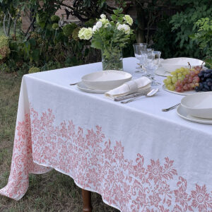 Floral tablecloth with porcelain plates, a vase of flower and grapes