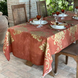Hand-painted linen tablecloth with gold motif on orange background