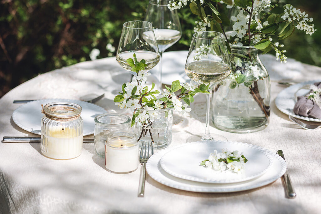 outdoor tablescape with linen tablecloth and white pillar candles on top