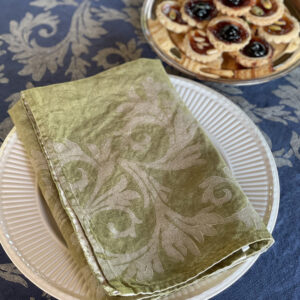 Folded green napkin laid on a plate and biscuits on a tray