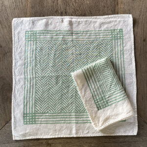 hand-printed chevron napkins in green mint colour laid on a wooden table