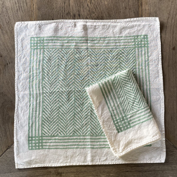 hand-printed chevron napkins in green mint colour laid on a wooden table