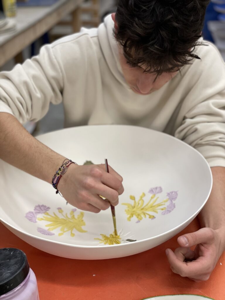 artisan hand-painting a porcelain bowl perfect for an exclusive and unique Christmas gift