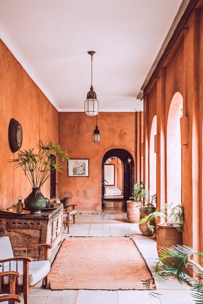 Mediterranean patio with peach fuzz painted walls and pots with plants
