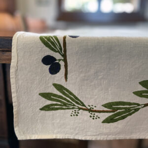 details of an organic linen table runner in olive design