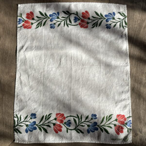 block-printed organic linen tea towel in wildflowers motif laid on a oak wood table