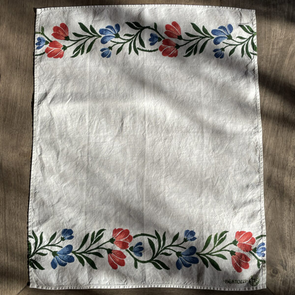 block-printed organic linen tea towel in wildflowers motif laid on a oak wood table