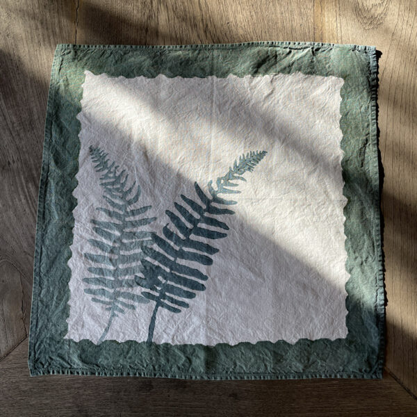 hand-printed fern linen napkin laid on a wooden table