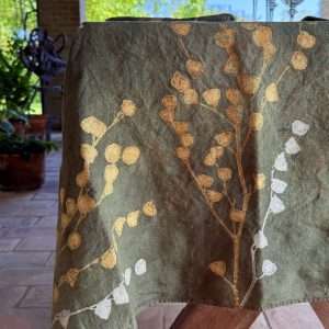 Detail of a gold and silver floral motif hand-printed on Italian luxury linen tablecloth