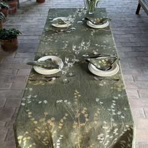 Hand-painted tablecloth in olive green laid with porcelain and matching napkins