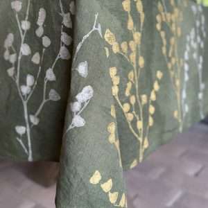 Botanical tablecloth detail of the floral motif in gold and silver colour