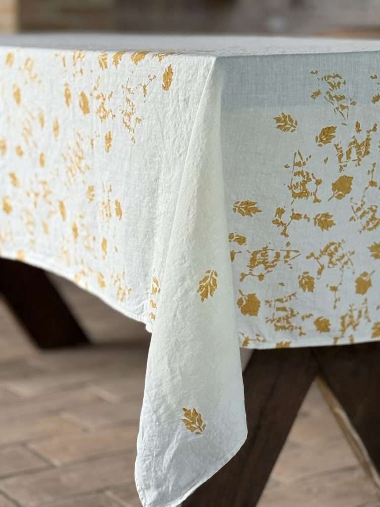 block-printed ochre leave onto a organic linen tablecloth