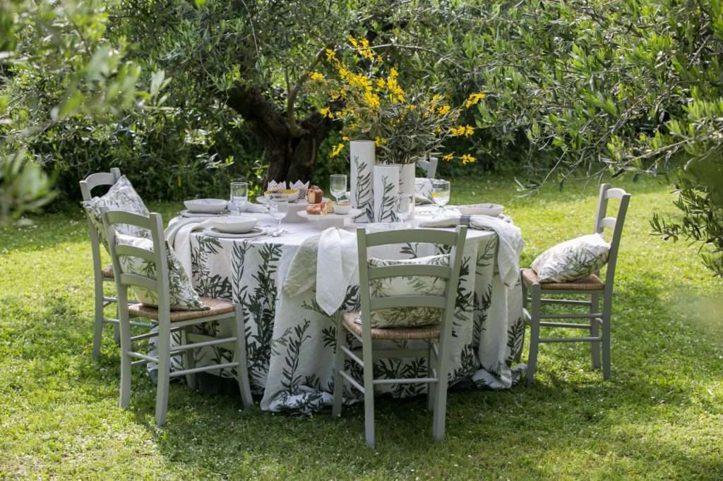 round table dressed with a large linen tablecloth in olive design