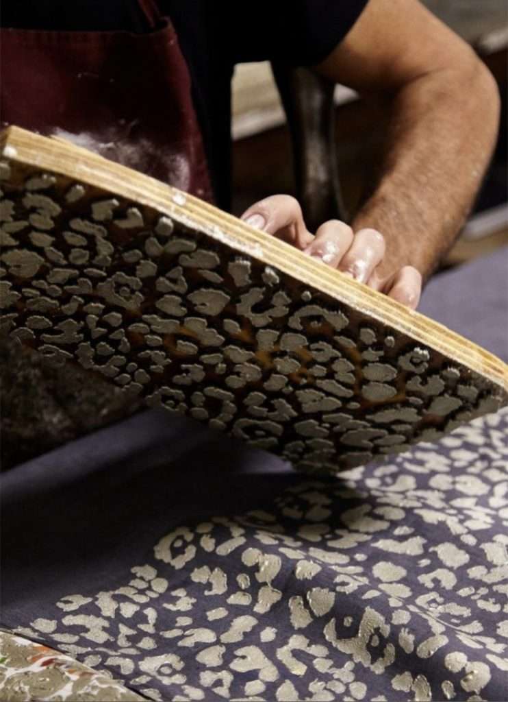 Italian artisan wood-block printing a Leopard design on fabrics