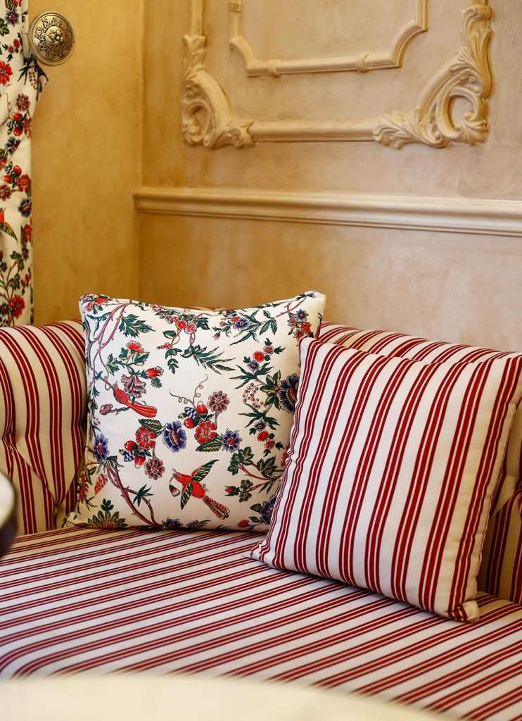 striped and feral cushion laid on a striped sofa