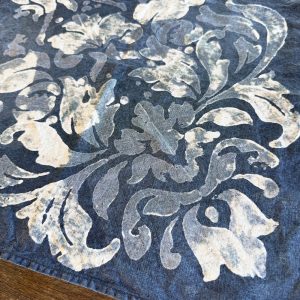 detail of a block-printed italian linen napkin in blue damask design